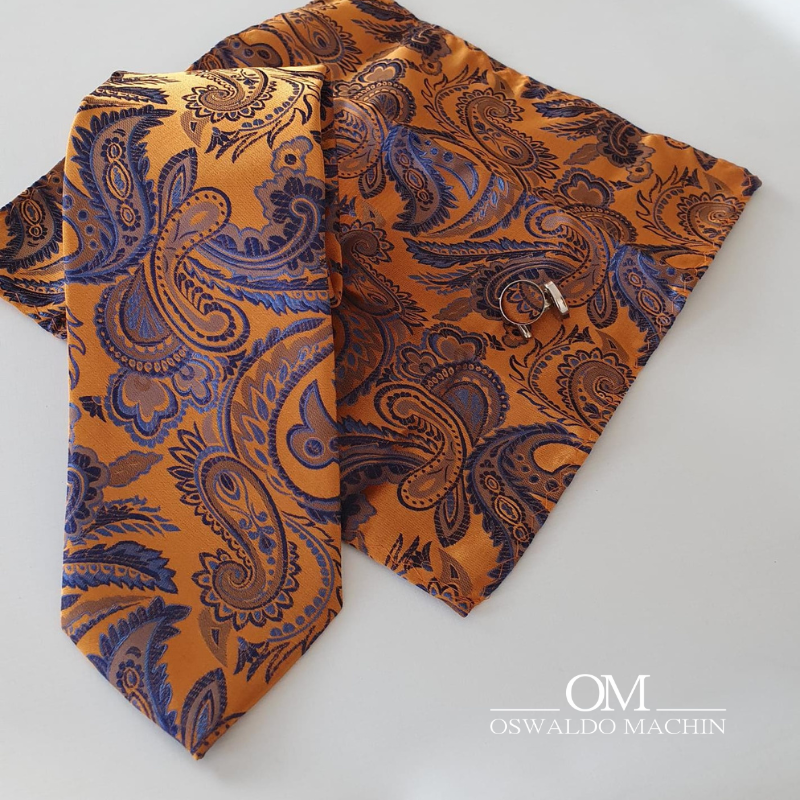 Pack corbata, pañuelo y gemelos, en tono naranja, con estampado de cachemir en tono azul y lila
