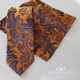 Pack corbata, pañuelo y gemelos, en tono naranja, con estampado de cachemir en tono azul y lila